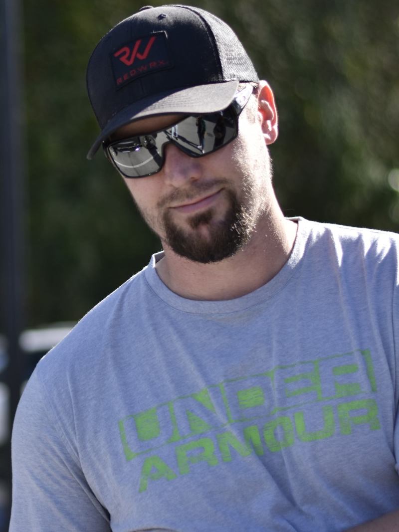 portrait of man wearing hat, sunglasses, and t-shirt